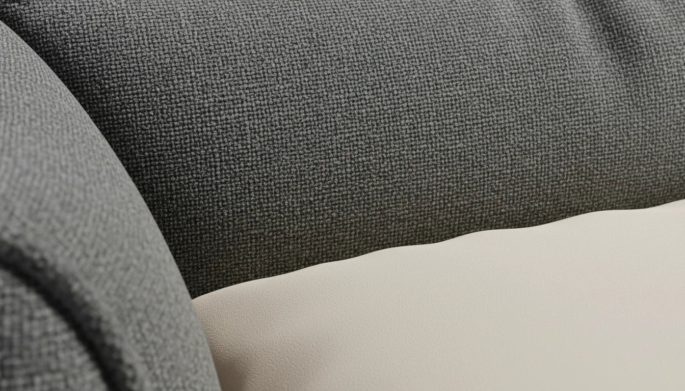 Close-up of a gray fabric surface with a textured weave pattern and a smooth off-white background